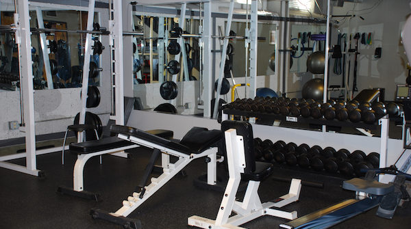 Empty gym weight bench and dumbbells