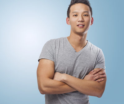 Young man smiling with arms crossed