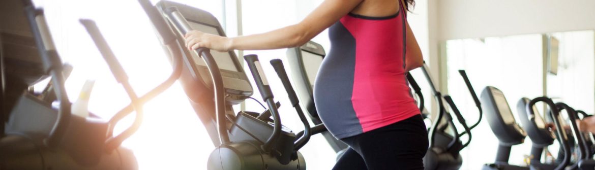 Person exercising on elliptical in bright gym
