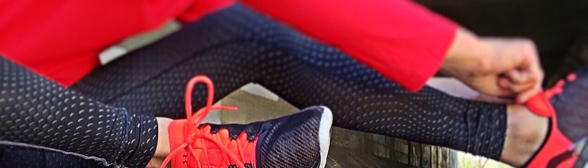Runner tying bright red running shoes