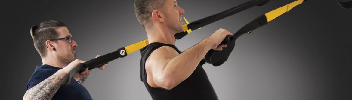 Man using suspension straps with trainer