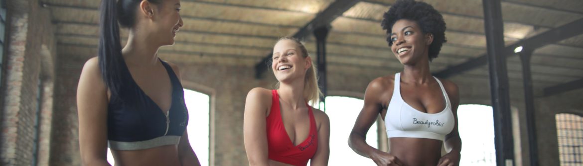 Three women laughing in fitness studio