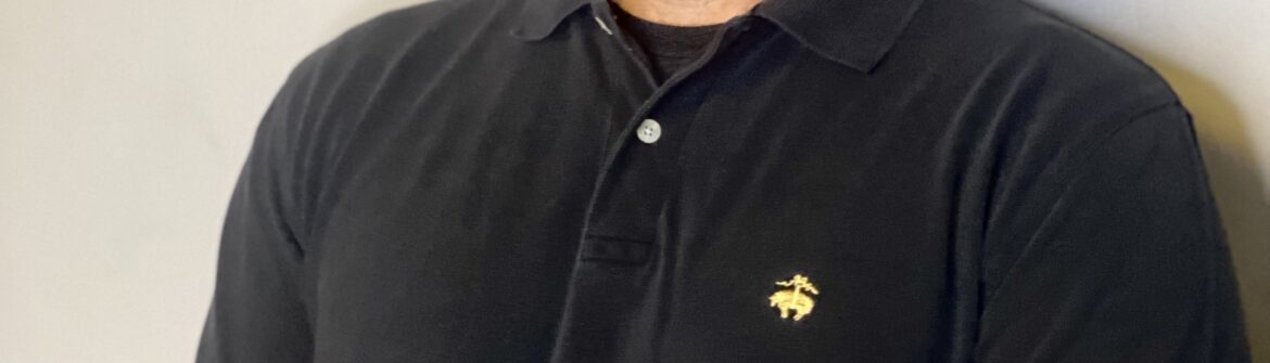 Smiling man wearing black polo shirt