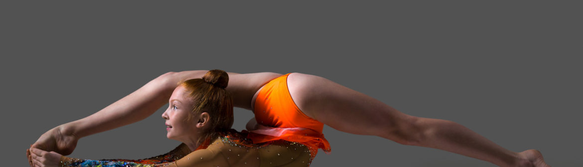 Contortionist performing extreme backbend in orange leotard